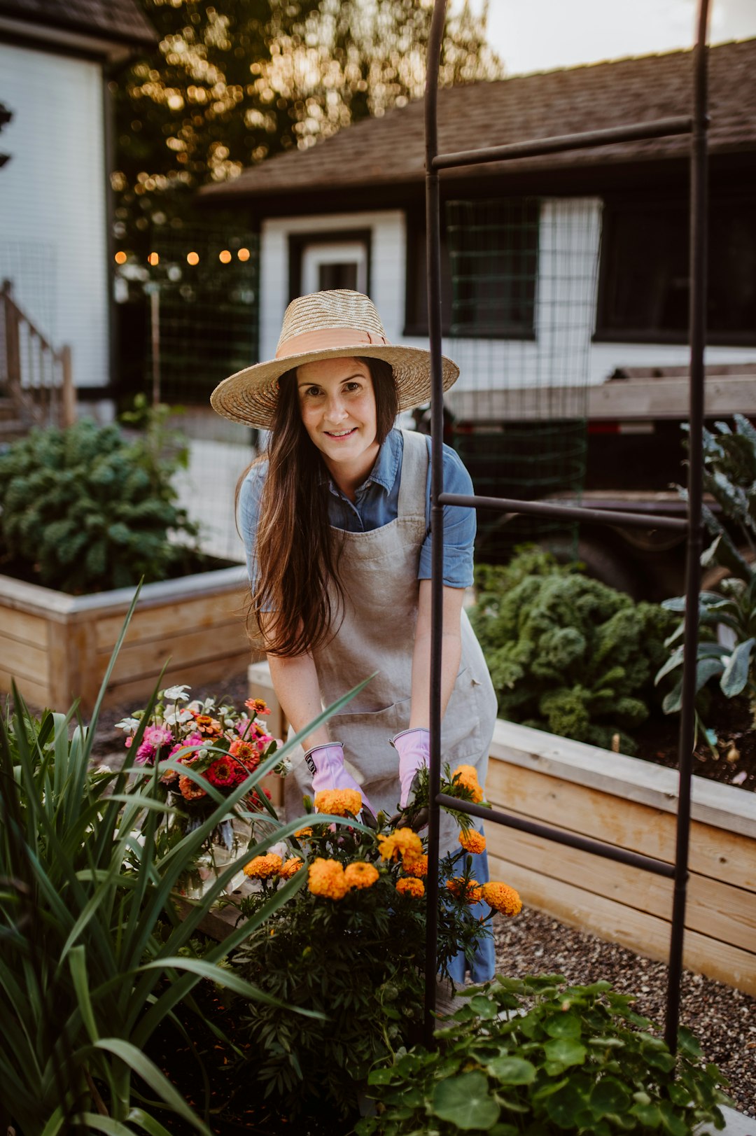 Gardener tending raised vegetable beds full of flowers and greens